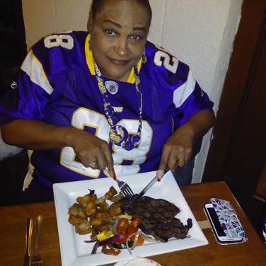 Dr. Khalilah Camacho Ali at Champps Americana watching the MN Vikings while eating a steak