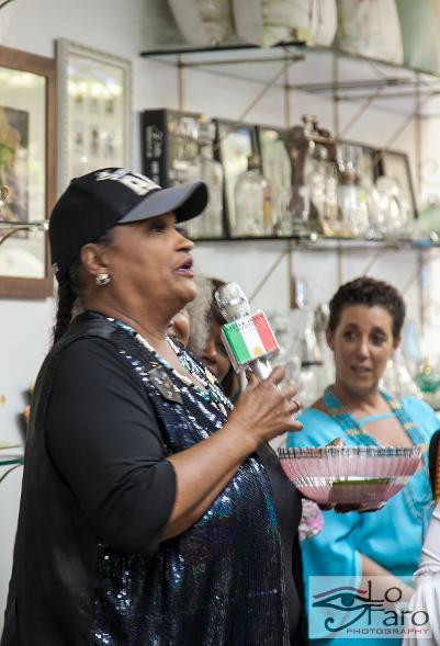 Doctor Khalilah Camacho-Ali speaking on the microphone at Her Royal Household